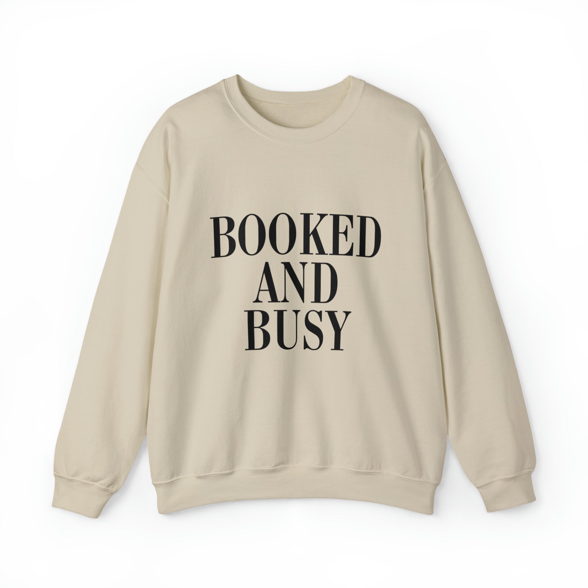 wearing a crewneck sweatshirt with the words "Booked and Busy" written in white on the front.