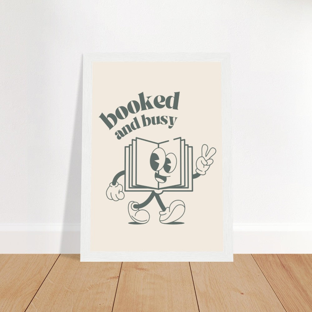A wooden framed poster with the words "Booked and Busy" in a bold black font.
